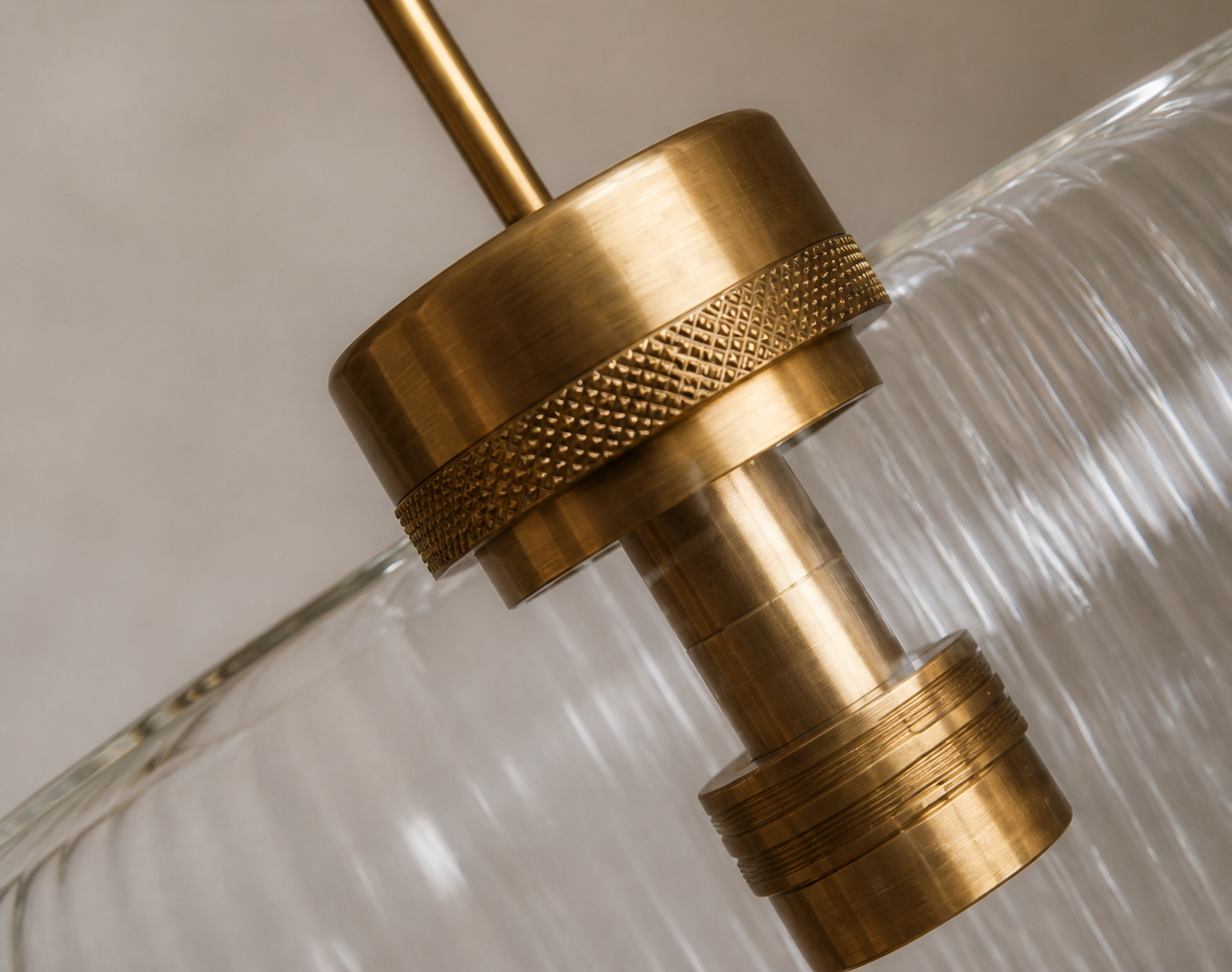 Close detail of a brushed brass lighting joint and ribbed glass